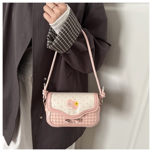 Pink plaid shoulder bag detail showing cute fruit patterns and a bow decoration
