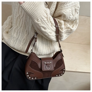 Detail of rivet splicing and silver metal ring on a brown crescent shoulder bag
