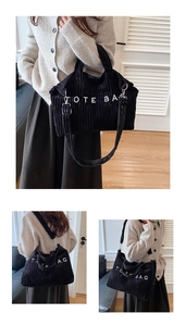 Detail of black corduroy tote bag with white text lettering and adjustable strap