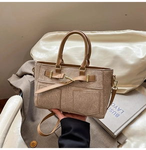 Detailed view of earth-toned patchwork handbag with gold buckles and adjustable strap