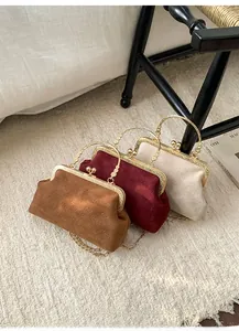 Detailed view of vintage shell bags in brown, wine red, and cream with metal chain straps