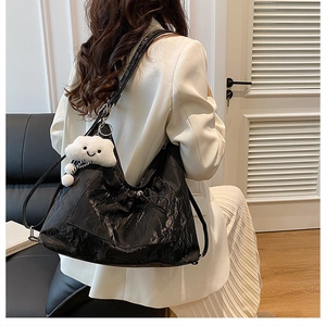 Borsa hobo nera in pelle con coulisse e ciondolo a nuvola indossata a tracolla