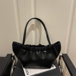 Minimalist black pleated faux leather tote bag with long handles and golden logo