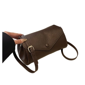 Retro dark brown cylinder crossbody bag with textured leather and gold hardware