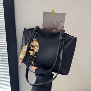 Classic black faux leather tote bag with contrast stitching and silk scarf accessory