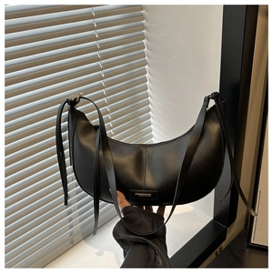 Detail of soft black vegan leather hobo bag with silver zipper and knot strap accent