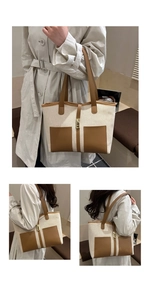 Close-up of beige canvas and brown leather tote bag with dual front pockets and metal lock