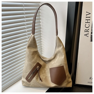 Close-up of canvas tote bag with brown leather pockets and high-quality metal zippers