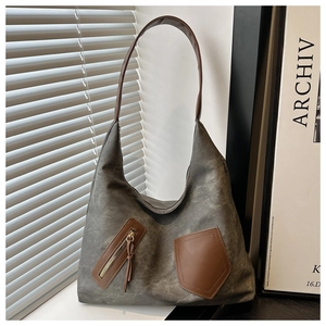 Close-up of grey washed canvas tote bag with brown leather patchwork and functional pockets