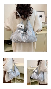 Dettaglio della borsa hobo argento con trama a pieghe e ciondolo a nuvola bianca di peluche
