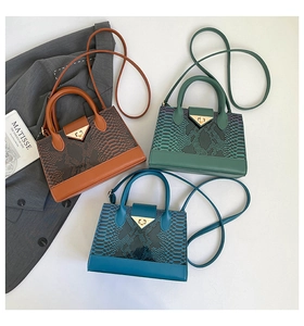 Detailed view of crocodile pattern crossbody bags in brown, green, and blue faux leather
