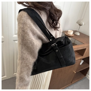 Detailed macro view of large black matte tote bag with adjustable metal buckle strap