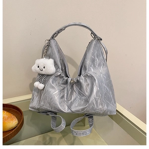 Dettaglio borsa metallizzata argento stropicciata con ciondolo a nuvola in peluche