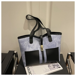 Macro view of blue marble texture tote bag with black leather pockets and gold metal buckle