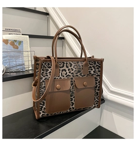 Close-up of leopard print tote bag featuring two front pockets and leather trim details