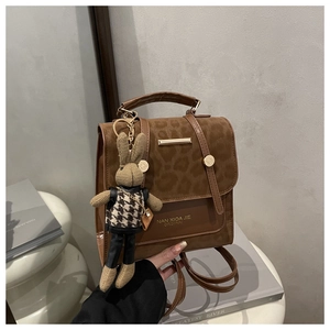 Close-up of leopard print handbag with magnetic closure and cute bunny doll pendant