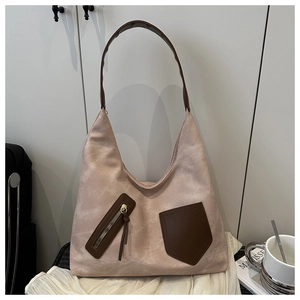 Detail of a large mauve suede tote bag with contrast brown straps and hobo silhouette