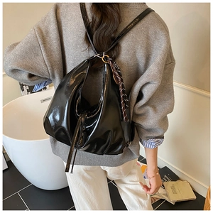 Glossy black patent leather hobo bag with trendy silk scarf detail shown on model back