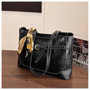 Close-up of black croc-embossed tote bag with contrast stitching and silk scarf wrap