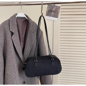 Detail of minimalist black suede-texture shoulder bag with zipper and dual straps