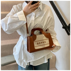 Modell mit Kontrast-Canvas-Tasche mit BEPRO-Stickerei und Lederdetails am Schultergurt