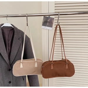 Detail view of suede underarm bags in beige and dark brown with matte texture