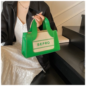 Detail der grün-beigen Color-Block-Handtasche mit BEPRO-Schriftzug, von Model gehalten