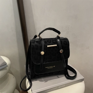 Chic black leopard print shoulder bag with gold metal buckle and brand logo detail
