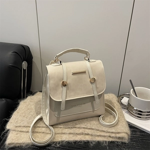 Chic beige faux leather backpack with gold studs on a warm minimalist lifestyle background