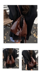 Close-up of deep brown glossy leather tote bag with soft folds and sleek shoulder straps