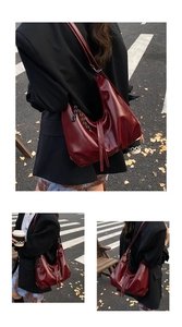 Detail of dark red glossy leather Hobo bag with stylish black and white braided rope accents