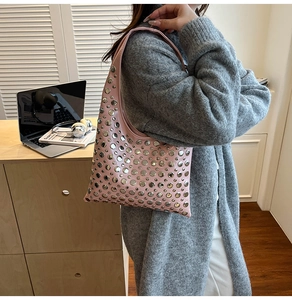 Gros plan du sac à bandoulière rose orné de rivets argentés en décor quotidien