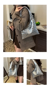 Détail d'un sac à main argenté métallisé avec des clous rivets ronds et fini brillant