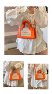 Detail of orange leather and canvas crossbody bag with BEPRO embroidery and shoulder strap