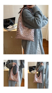 Détail du sac sous le bras en cuir rose avec des rivets métalliques argentés et une bandoulière