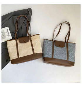 Detail of color-block tote bags with textured fabric and dark brown leather accents