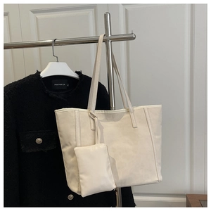Vue détaillée du sac cabas blanc crème avec coutures verticales et mini pochette assortie
