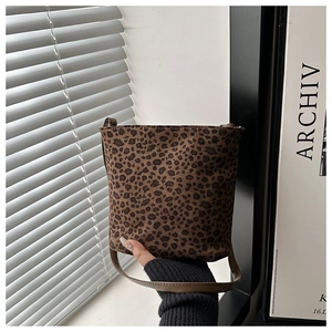 Detail of leopard print bucket bag with suede texture and brown crossbody strap