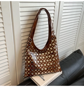Détail des rivets argentés sur un sac hobo vintage marron en similicuir texturé
