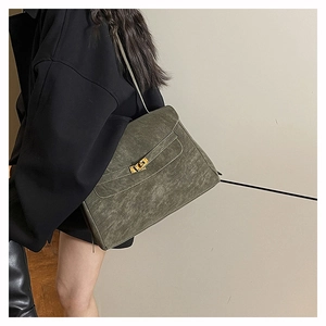 Detail view of large dark green vintage leather briefcase bag worn by model