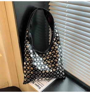 Vue détaillée du sac à bandoulière en cuir noir brillant avec des rivets argentés