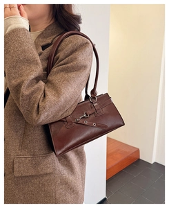 Detaillierte Makroansicht der dunkelbraunen Vintage-Schultertasche aus glattem Kunstleder