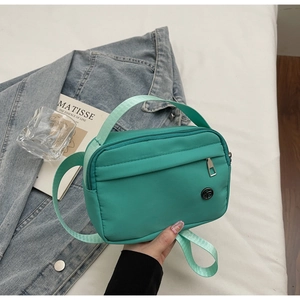 Detail of mint green nylon tote bag featuring water-resistant fabric and adjustable strap