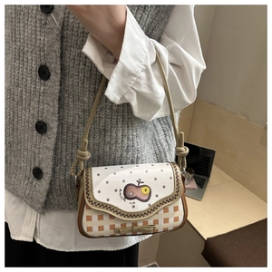 Detail of crossbody bag with apple embroidery and knot shoulder strap detail