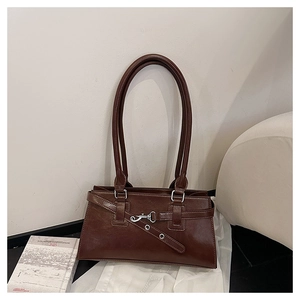 Detaillierte Makroansicht der braunen Lederstruktur und Vintage Metallschnalle der Tasche