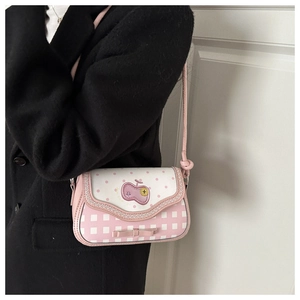 Detail of pink plaid crossbody bag with apple embroidery and bow on a wool coat