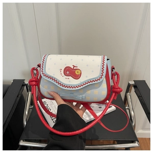 Detail of crossbody bag with cherry embroidery, blue checkerboard pattern and red knot strap
