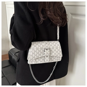 Detail of a chic crossbody flap bag featuring letter M monogram and a silver metal buckle