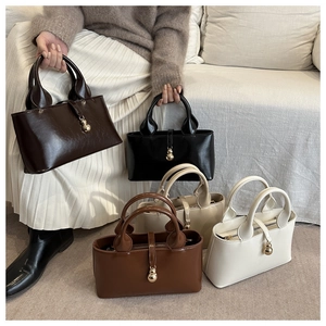 Detail view of colorful faux leather baguette bags with decorative gold hardware