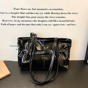 Minimalist black patent leather tote bag with vintage belt buckle and shoulder straps